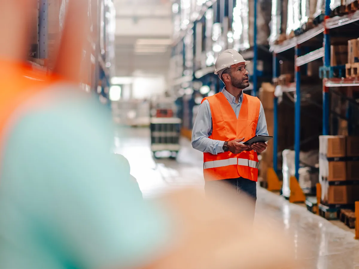 Warehouse workers managing inventory and logistics with digital tablet