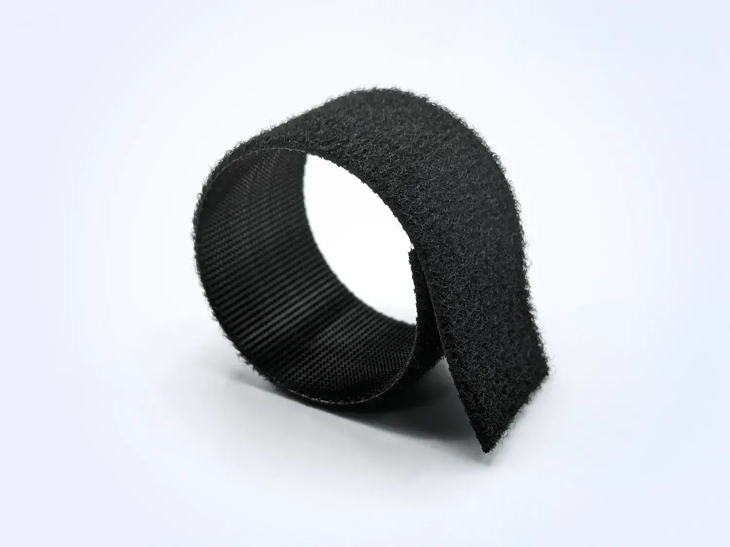 Roll of black HALCO® Back2Back self-engaging hook and loop bundling tape